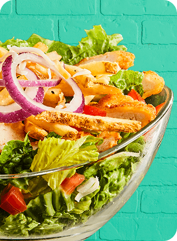 bowl of salad on a green brick backround