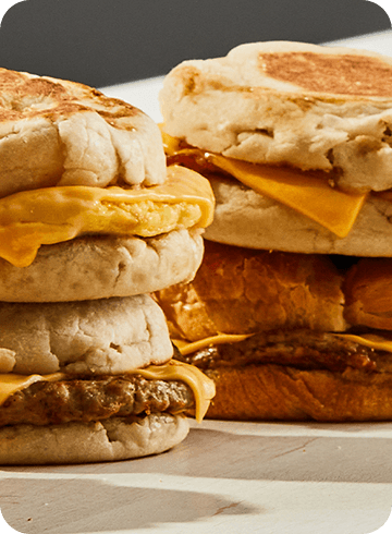 breakfast sandwiches stacked on top of each other on a counter