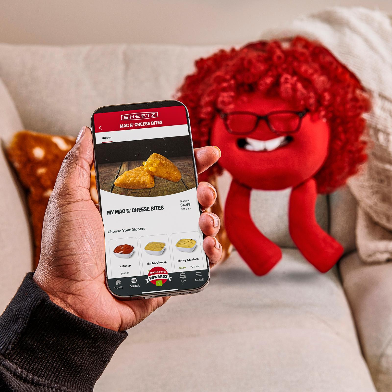 sheetz mobile app being held in front of a Sheetz Freak