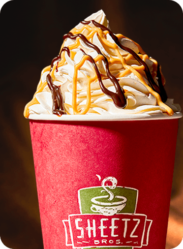 hot mocha with whipped cream on a table with a dark background